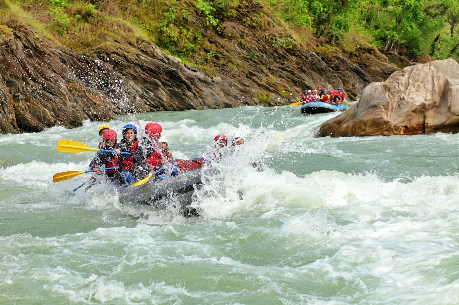 Eine Person gleitet an einer Zipline hoch über einem Fluss