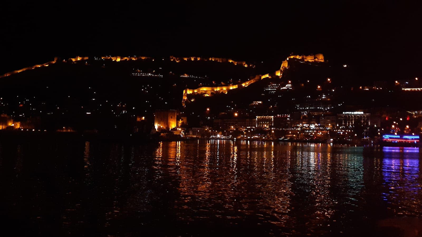 Hafen von Alanya und die beleuchteten Burgmauern bei Nacht