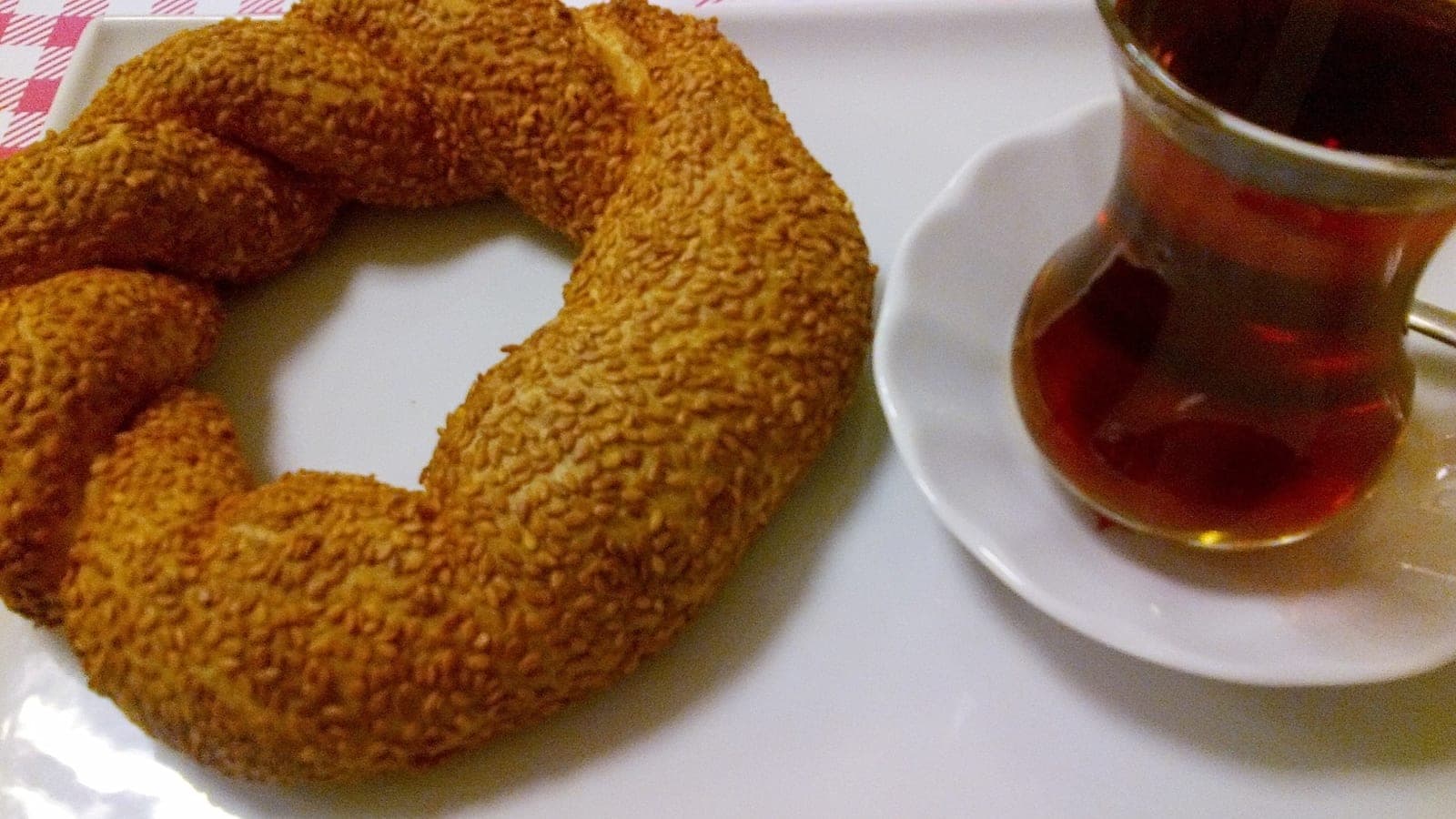 Glas Tee neben einem Sesamkringel Simit