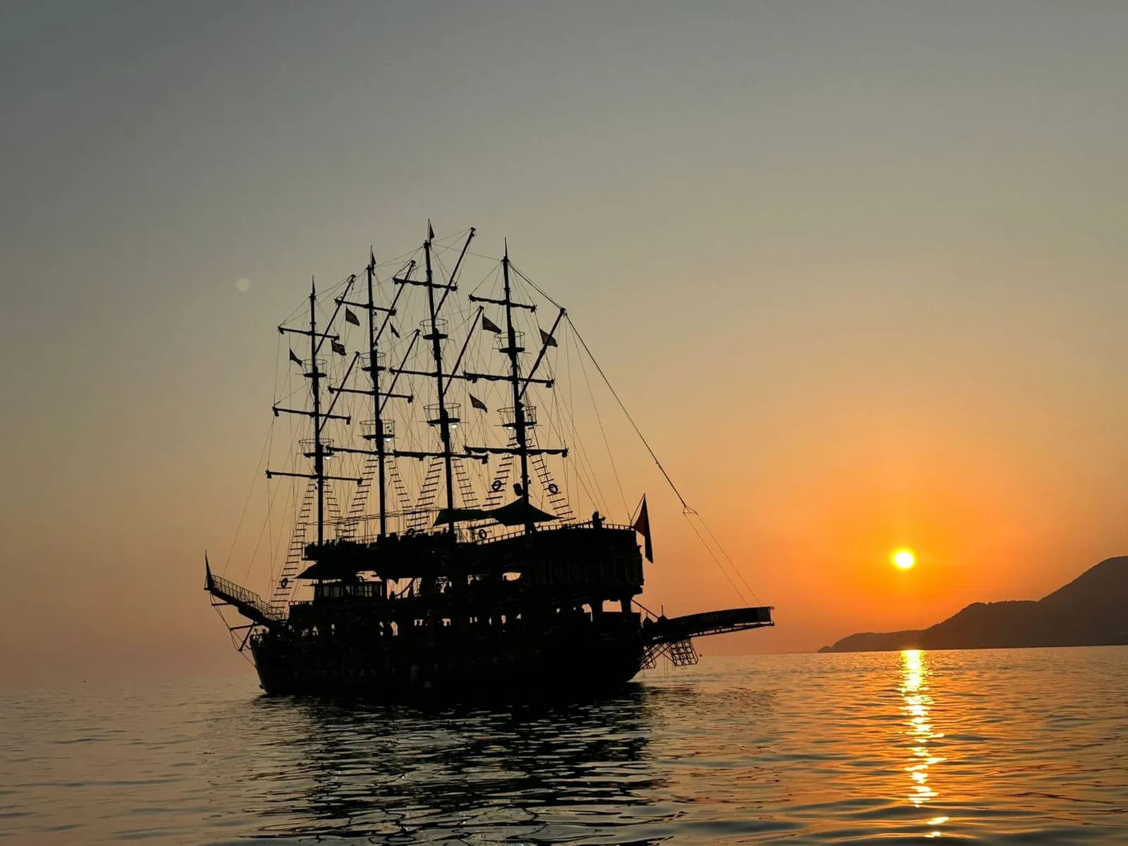 Ein großes Ausflugsboot auf dem Mittelmeer vor der Küste von Alanya während des Sonnenuntergangs
